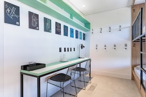A modern office space with a desk, chairs, a coffee machine, and a wall with numbered slots.