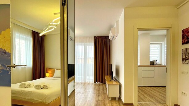 Une chambre d’hôtel équipée d’un lit, d’un bureau, d’une télévision et d’une kitchenette.