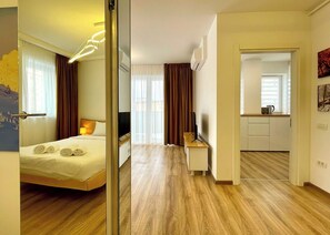 Een hotelkamer met een bed, bureau, televisie en kitchenette.