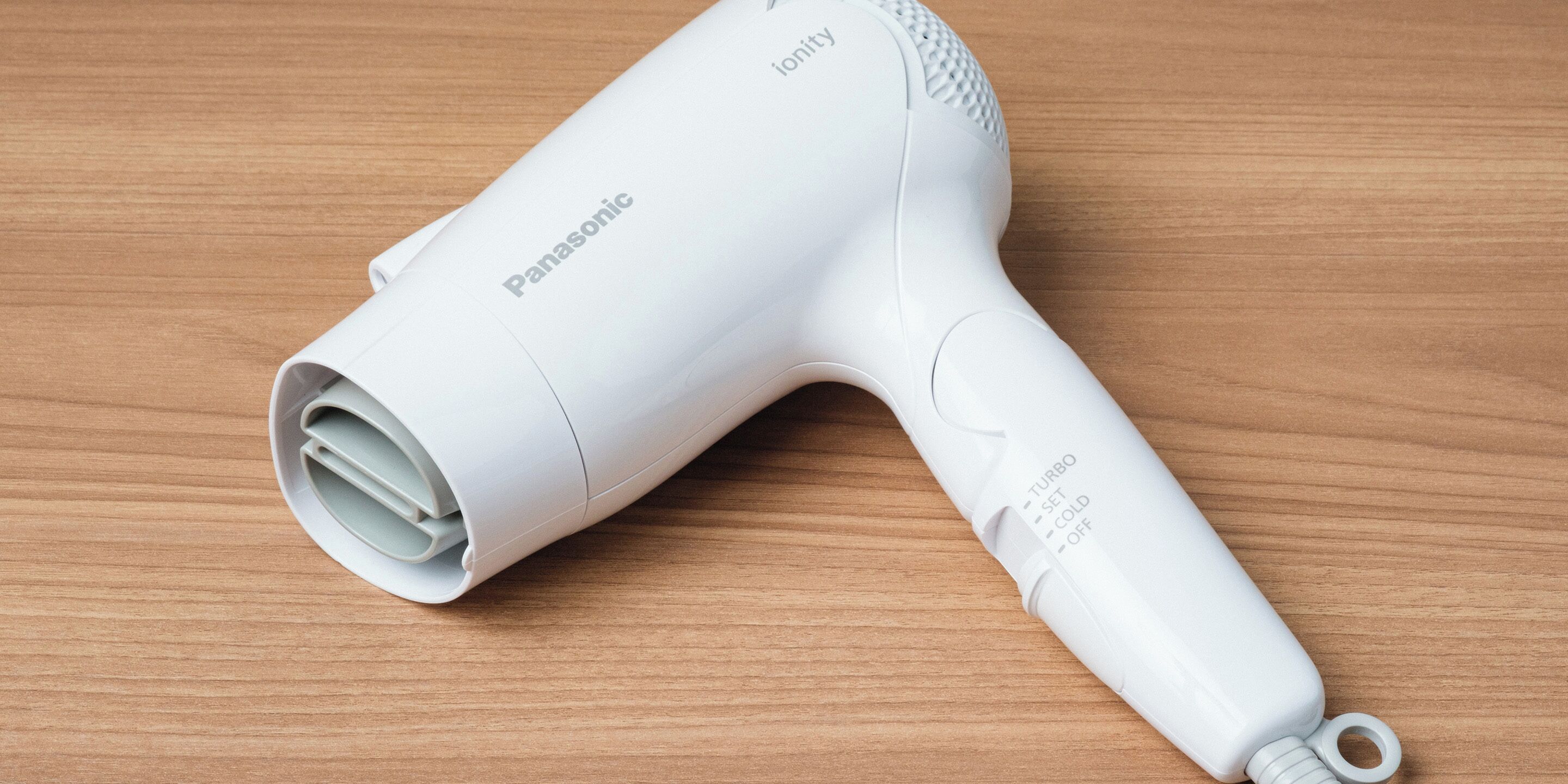 A Panasonic hair dryer on a wooden surface.