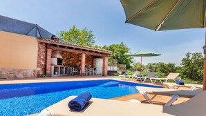 A swimming pool with lounge chairs and a barbecue area. - Vacation home Esteva by Interhome (Maçanet de la Selva)