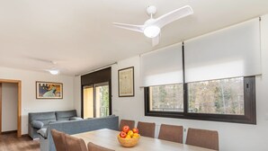 A modern living room with a dining table, sofas, and a ceiling fan. - Vacation home Esteva by Interhome (Maçanet de la Selva)