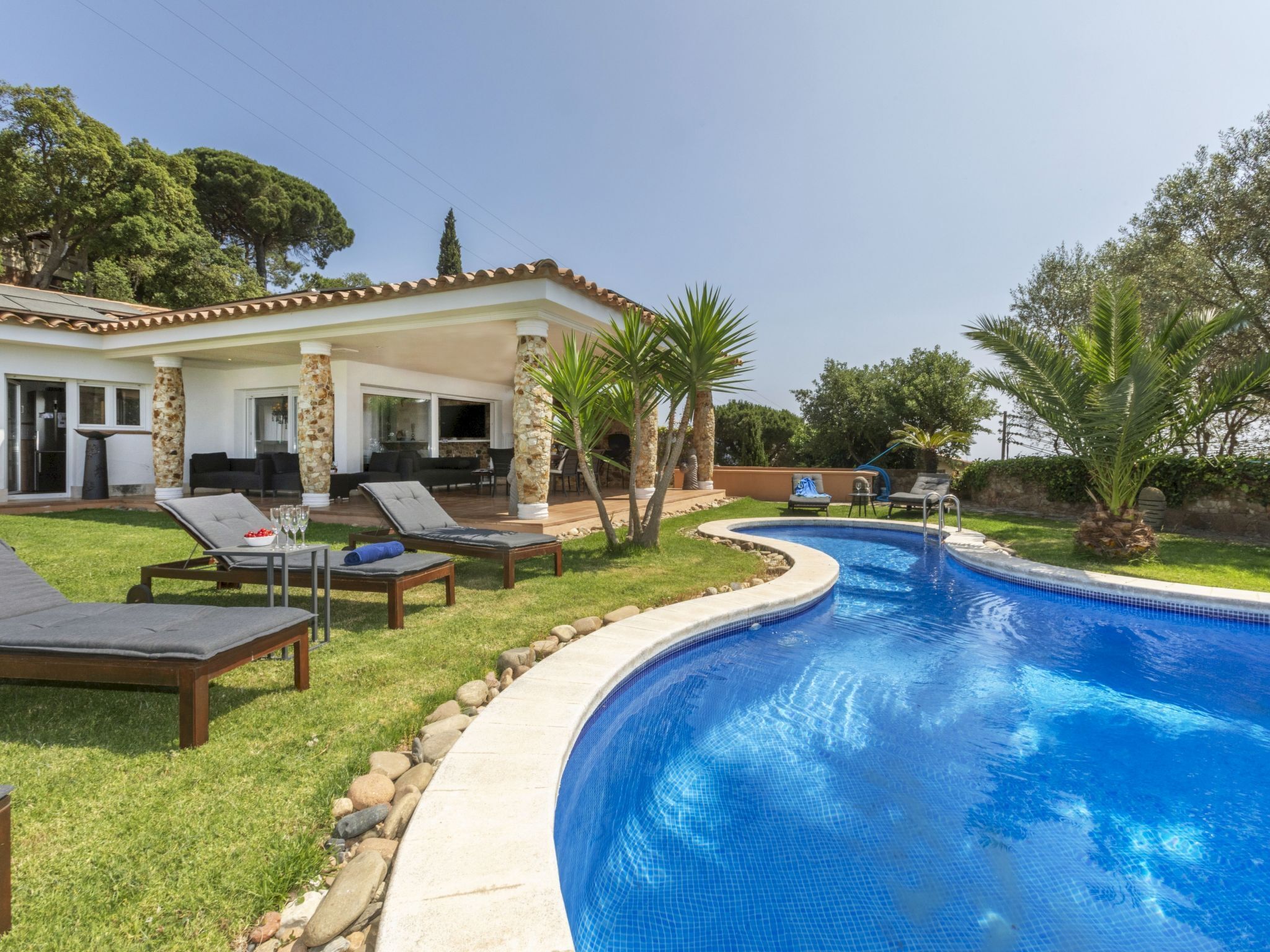 Una piscina con lettini e una zona patio coperta.
