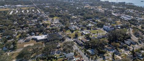 An aerial view of a residential area with houses, streets, and a bridge in the background.