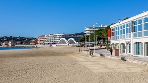 Un hotel frente a la playa con un amplio patio, un restaurante y vista al mar.
