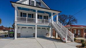 A two-story house with a balcony, a garage, and a staircase leading to the second floor.
