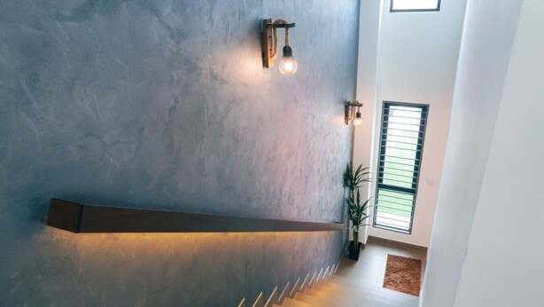 Een moderne trap met een betonnen muur, een ingebouwde bank en een raam met jaloezieën.