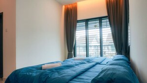 Een slaapkamer met een bed, gordijnen en een raam.