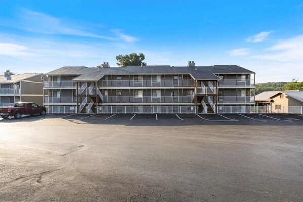 Un motel à plusieurs étages doté d’une cour intérieure, de balcons et d’un parking.