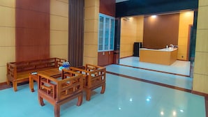 A hotel room with a wooden dining set, a large window, and a reception desk. - MITI House (Ha Tien)