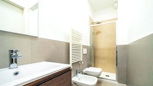 A modern bathroom with a large sink, bidet, and glass shower enclosure. - Modern & Bright Apartment near Porta Garibaldi (Milano)