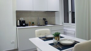 A compact kitchen with a white countertop, a sink, and a window with blinds. - Modern & Bright Apartment near Porta Garibaldi (Milano)