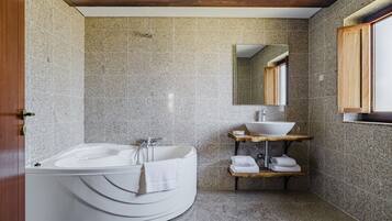 Ein modernes Badezimmer mit freistehender Badewanne, einem Holzlagerraum mit Waschbecken und einem Spiegel darüber.