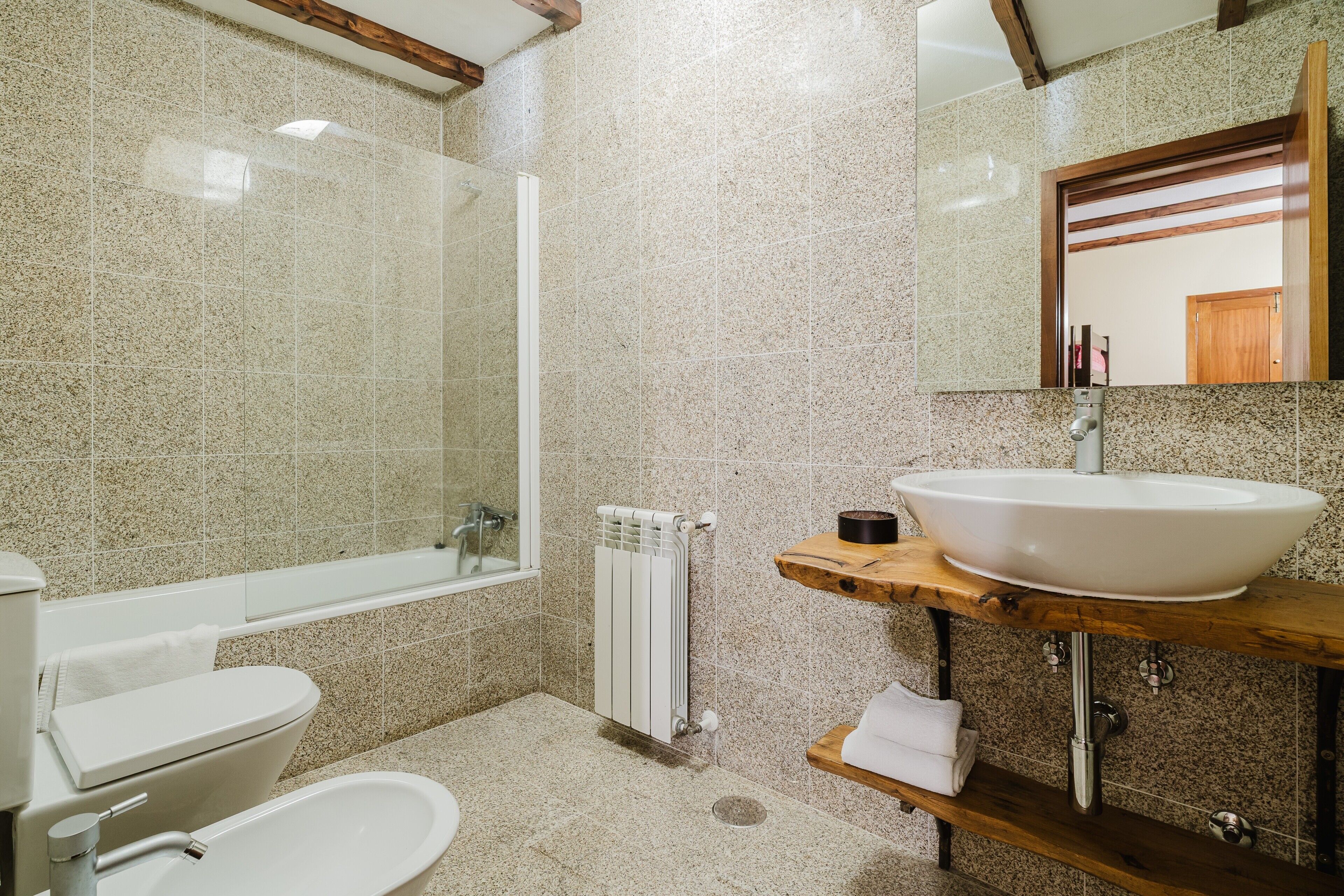 A bathroom with a bathtub, toilet, sink, and a mirror.