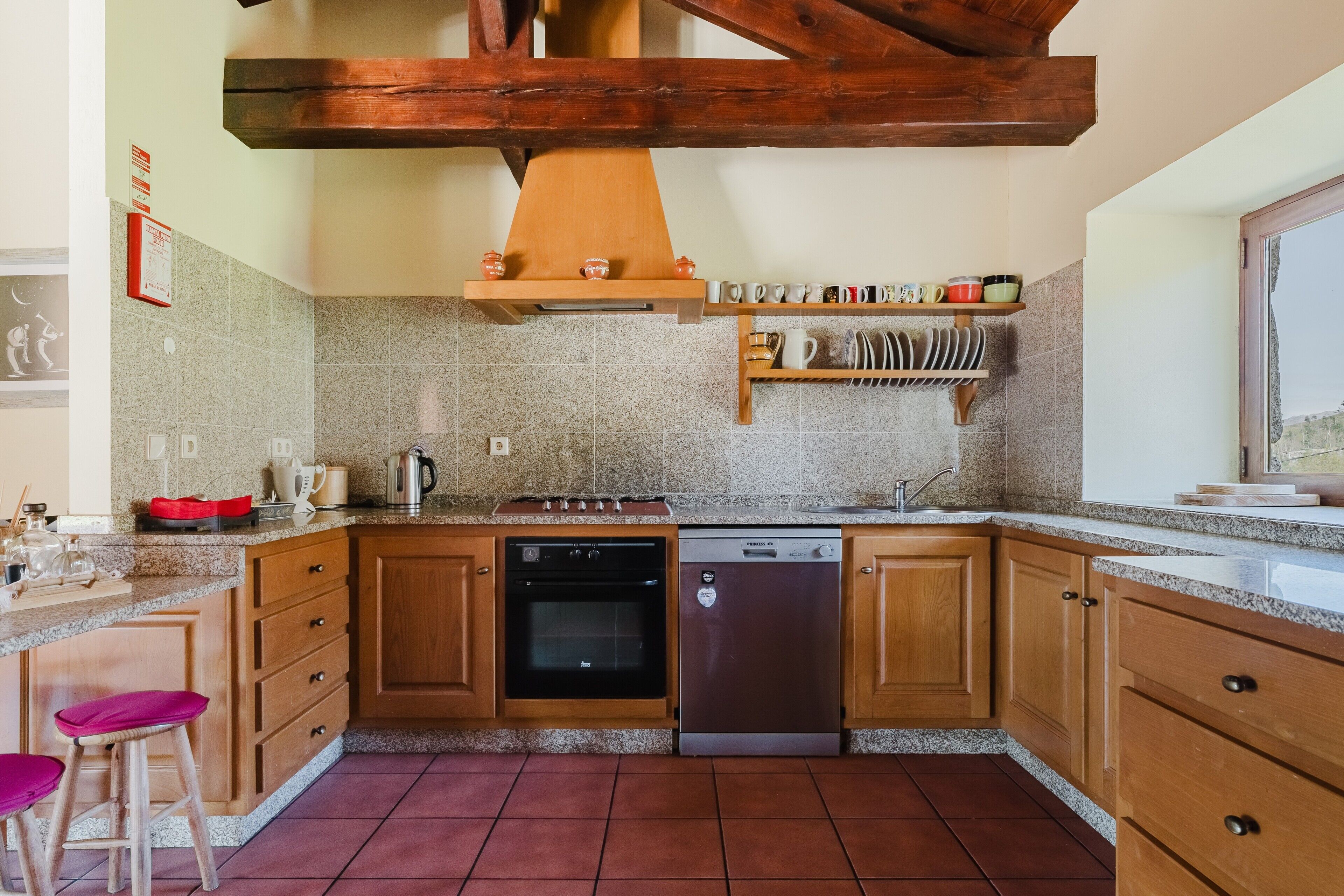 Una cocina con armarios de madera, estufa, horno y lavavajillas.