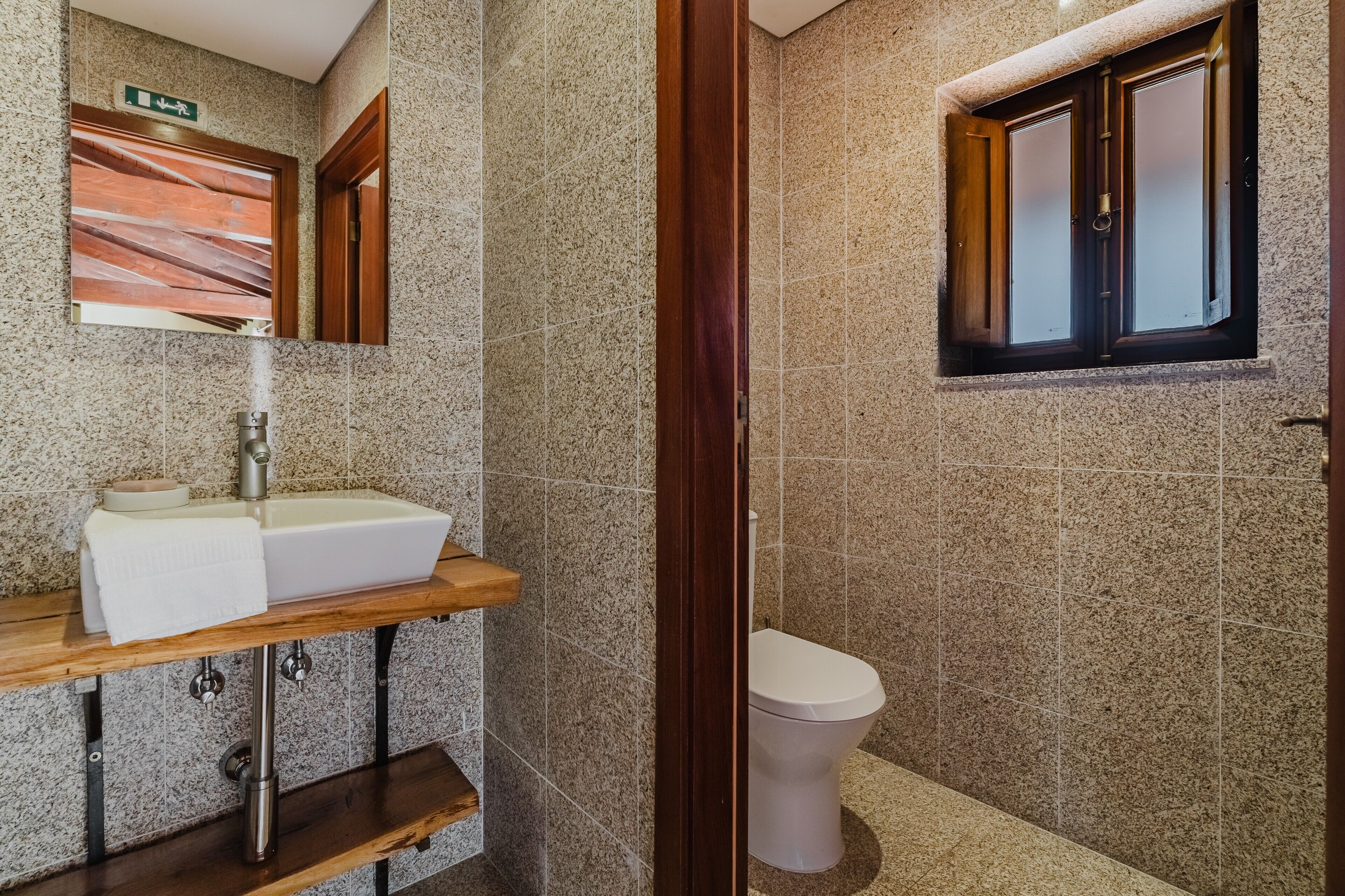 A bathroom with a sink, mirror, and toilet.
