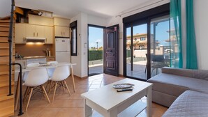 Un apartamento moderno con cocina, comedor y sala de estar con sofá y mesa.