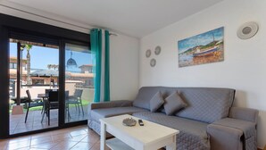Una sala de estar con un sofá, una mesa de centro y un cuadro en la pared.