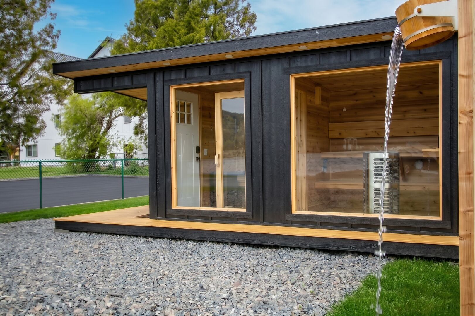 A modern cabin with a wooden exterior, large glass windows, and a water feature.