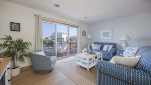 A living room with a sofa, armchair, coffee table, and a potted plant. - 4203 - Here Comes the Sun - Duck Oceanside Condo | Community Pool & Beach (Duck)