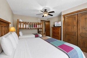 A hotel room with a large bed, a ceiling fan, wooden wardrobe, and a sign for Table Rock Resorts.