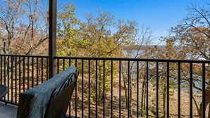 A covered outdoor area with a view of trees and a body of water. - Modern Walk-In Lakefront Condo, Sleeps 8.  Ticket Deals and close to Silver Dollar City! (Branson)