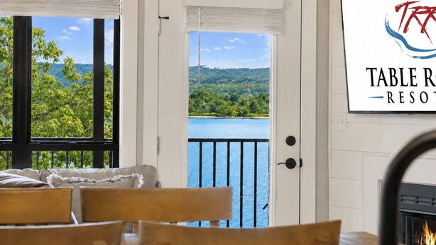 A room with a view of a lake, a fireplace, and a sign for Table R. - Walk to Table Rock Lake • Family Friendly • Minutes to SDC (Branson)