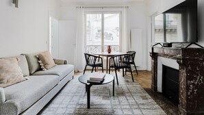 Un salon moderne avec un canapé, une table basse, une cheminée et un téléviseur.