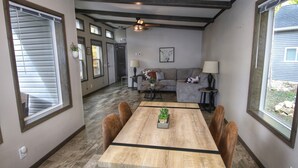 Un comedor con una mesa y sillas de madera, un sofá y un ventilador de techo.