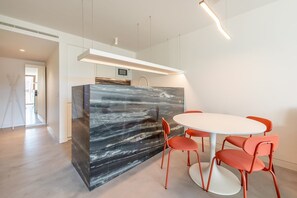 Modern space with a central island, round table, and sleek kitchen area.
