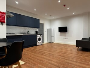 Enjoy a compact yet functional stay with a kitchen area, flat-screen TV, dining table, and comfortable seating area.