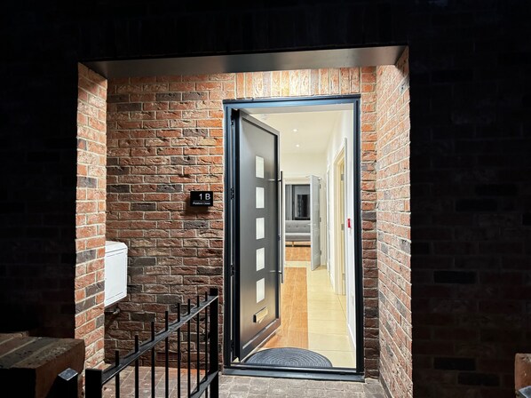 Enter a welcoming space with a modern door leading to a hallway featuring a bed and accessible accommodations.