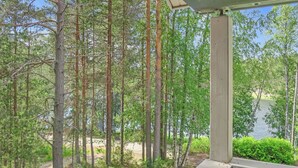 Udsigt fra en veranda over et skovområde med en sø.