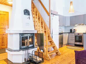 Een moderne keuken met een ingebouwde open haard, een houten trap en moderne apparaten.