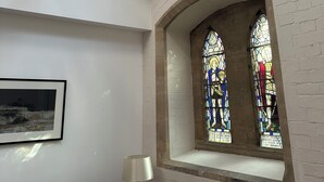 A room with a chandelier, a stained glass window, a framed picture, and a lamp. - The Nave a unique duplex apartment in a historic converted church near to beach. (Waterloo)
