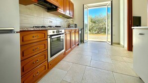 Une cuisine moderne avec des meubles en bois, un four encastré et une cuisinière à gaz.