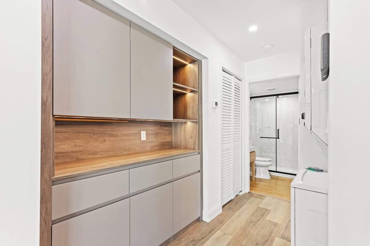 A modern kitchen with built-in cabinetry and a wooden countertop.