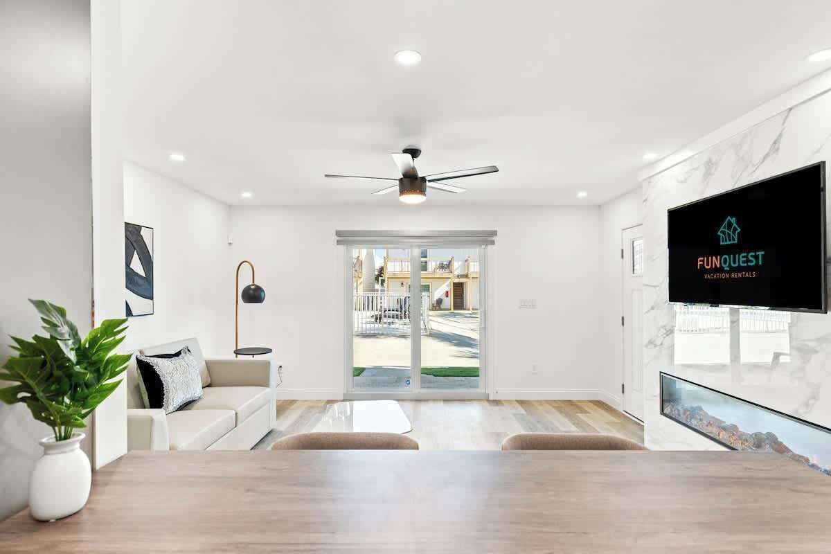A modern living room with a sofa, a coffee table, and a TV mounted on the wall.