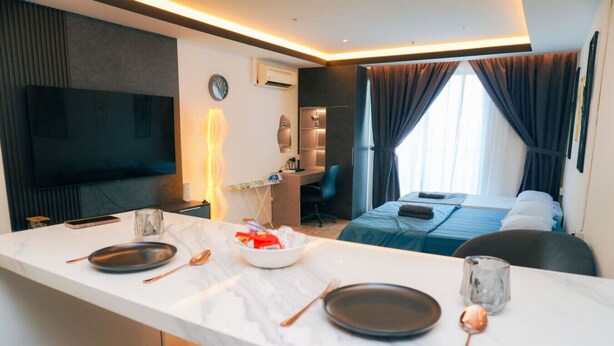 A modern hotel room with a dining area, a bed, a TV, and a desk. - iSovo-iCity#3slep#Studio#netflix (Shah Alam)