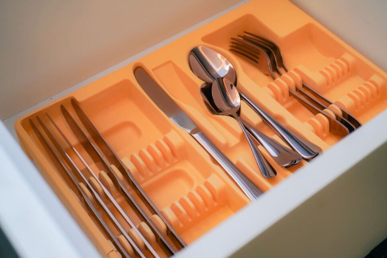 A drawer with utensils neatly organized in compartments.