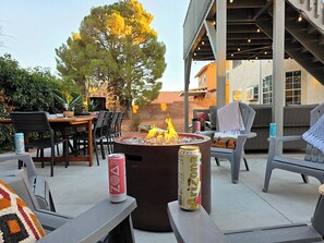 Un espace extérieur aménagé avec une terrasse, un foyer, des sièges et une bière.