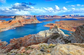 Vista panorámica de un cañón con un río, terreno rocoso y montañas distantes.