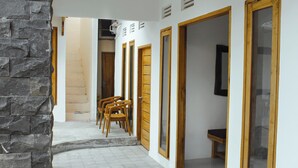 Un pasillo con paredes de piedra, puertas de madera y piso de baldosas.