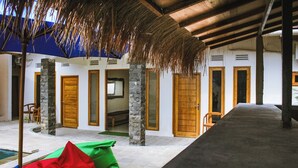 Un espacio al aire libre cubierto con piscina, puertas de madera y pilares de piedra.