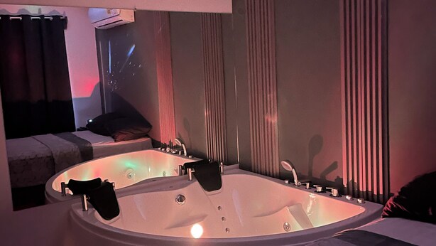 Een moderne badkamer met een groot bad, een spiegel en een douchehoek.