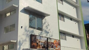 En byggnad med flera våningar, och en skylt som visar att det är ett hotell.