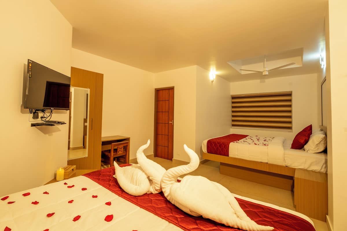 A hotel room with a bed, a desk, a wardrobe, and a television.