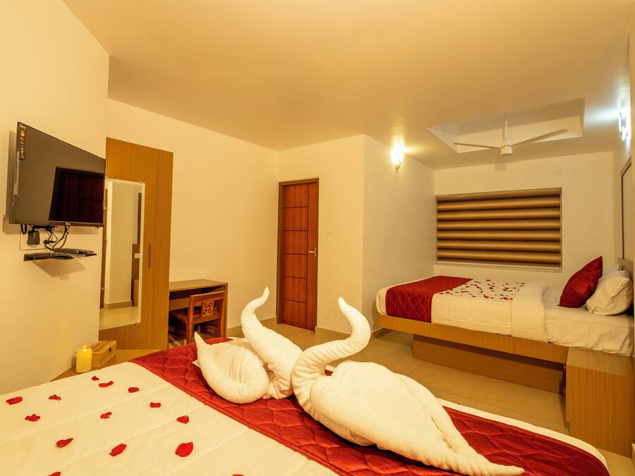 Una habitación de hotel con cama, escritorio, armario y televisor.