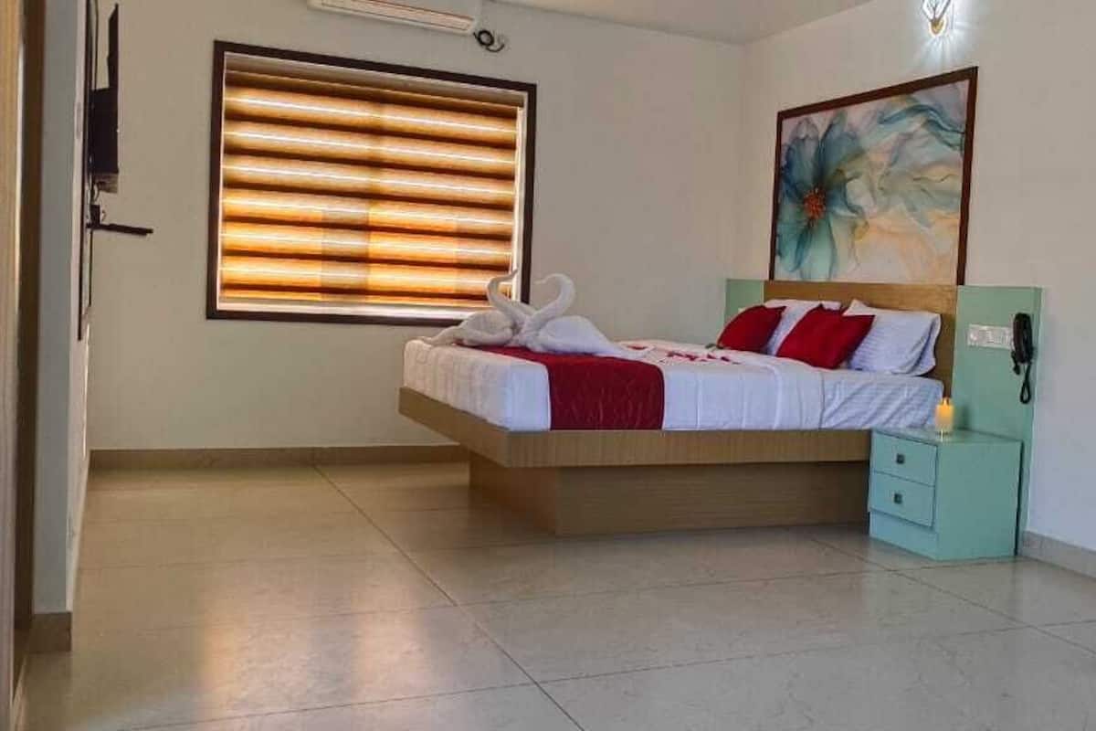 A bedroom with a bed, bedside table, and a window with blinds.