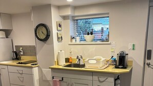 A modern kitchen with a built-in oven, a sink, and a window with a view.
